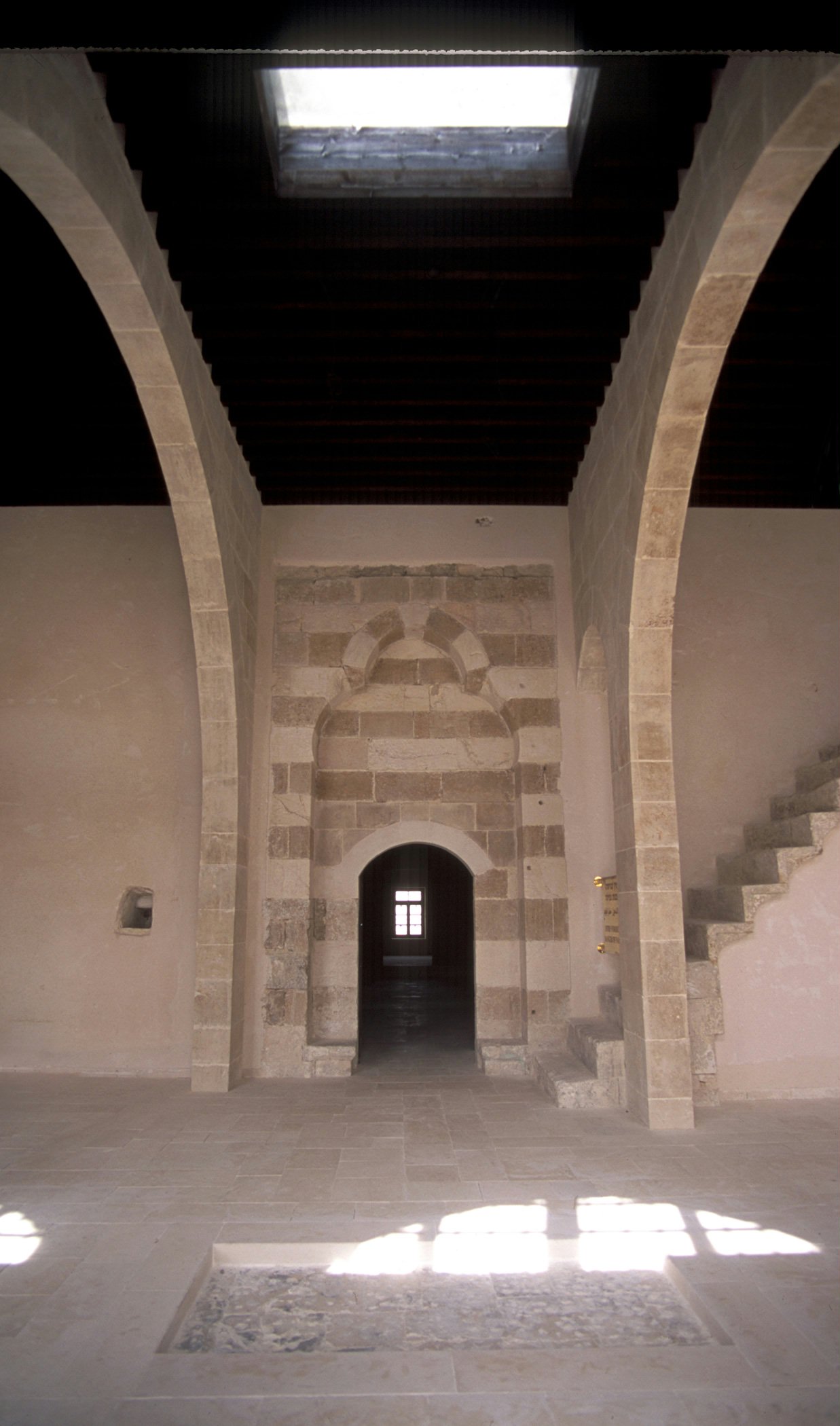 Skylight in the ceiling of the citadel and the uncovered stone at the place where Mirza Mihdi fell. In the background is the doorway that leads to rooms including the cell of Baha'u'llah. (2004)