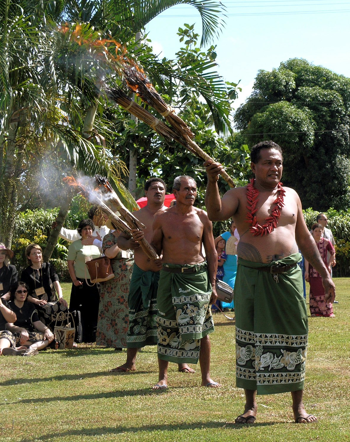 Samoan men bearing torches during a jubilee reception at the residence of the Head of State.
