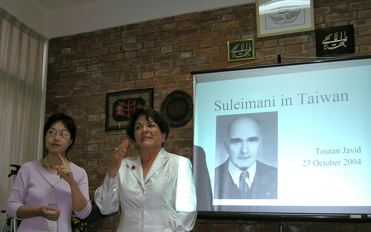 Touran Javid (right), a relative of the Suleimanis, addressing the anniversary gathering with the assistance of an interpreter.