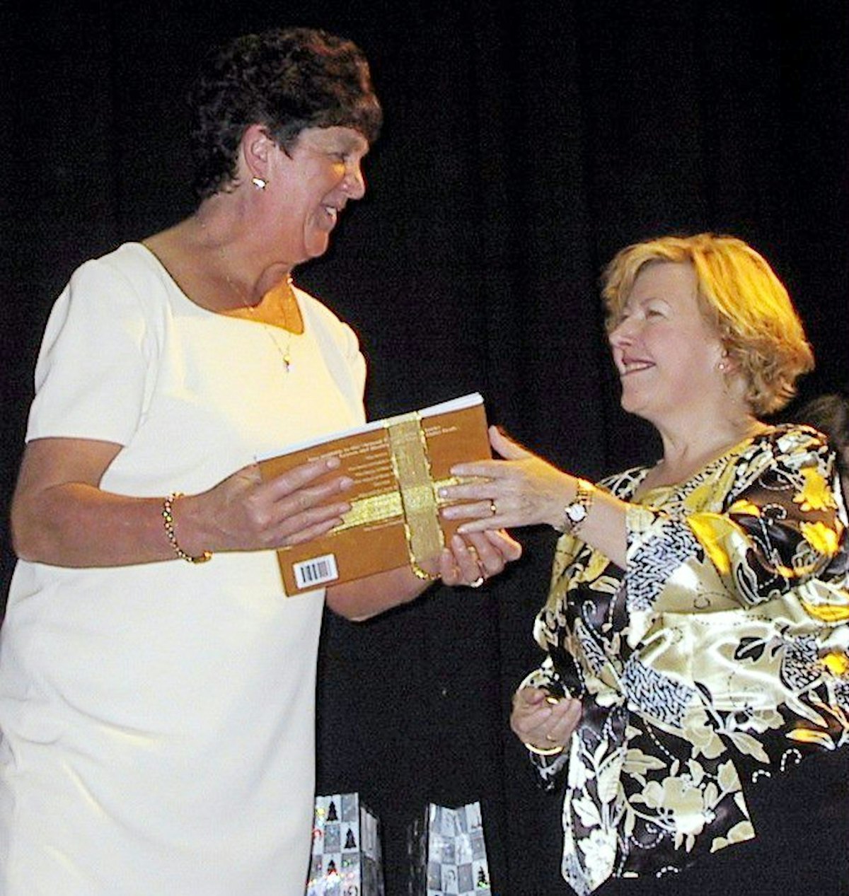 The Victorian state parliamentary secretary for education, Liz Beattie (right), presents a gift to Rose Walthers, the assistant principal of Bulleen Heights School in Manningham, Australia, at a teacher appreciation event organized by the local Baha'i community.