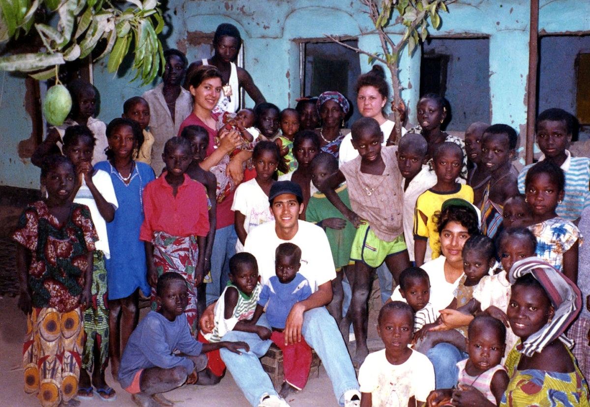 Residents of the village of new Yundun in The Gambia with visiting Baha'is from Canada and the United States, who were contributing to children's classes and literacy classes. 1993.