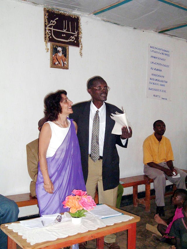 Higiro Anastase, a brother of the first Bahá'í of Rwanda, Alphonse Semanyenzi, speaking at the Rwandan jubilee celebrations about historical events. Mr. Anastase is a member of the National Spiritual Assembly of the Baha'is of Rwanda, as is Hayede Parsa (left.