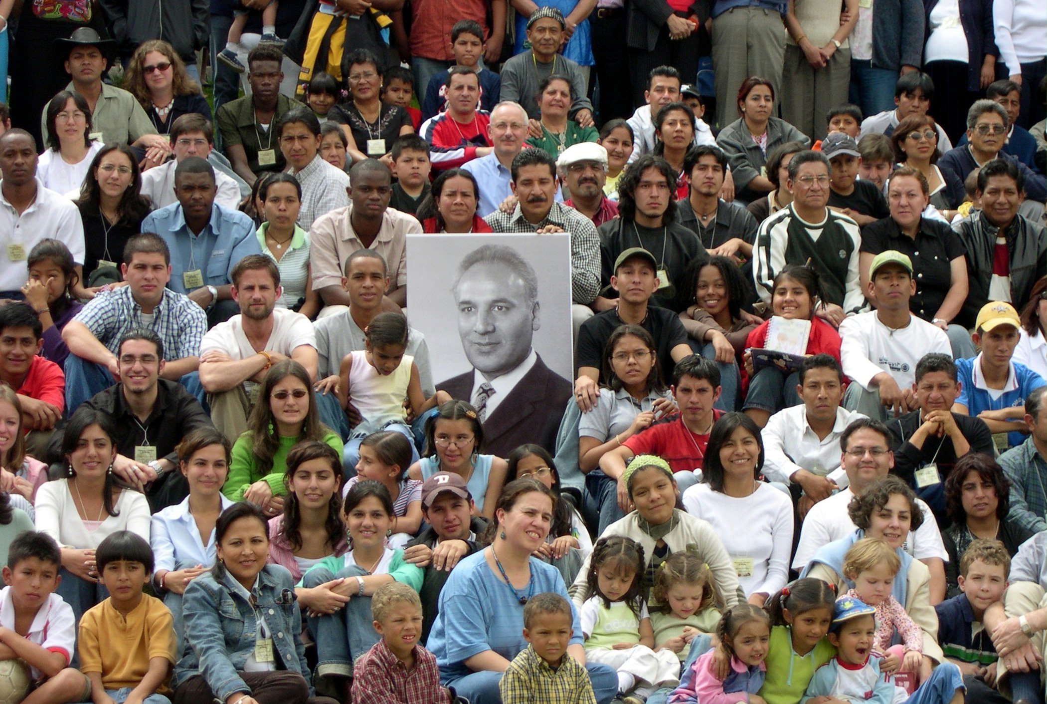 Some of the participants at the "Growth and Victories" conference in Ecuador with a photograph of Hand of the Cause of God Dr. Rahmatu'llah Muhajir.