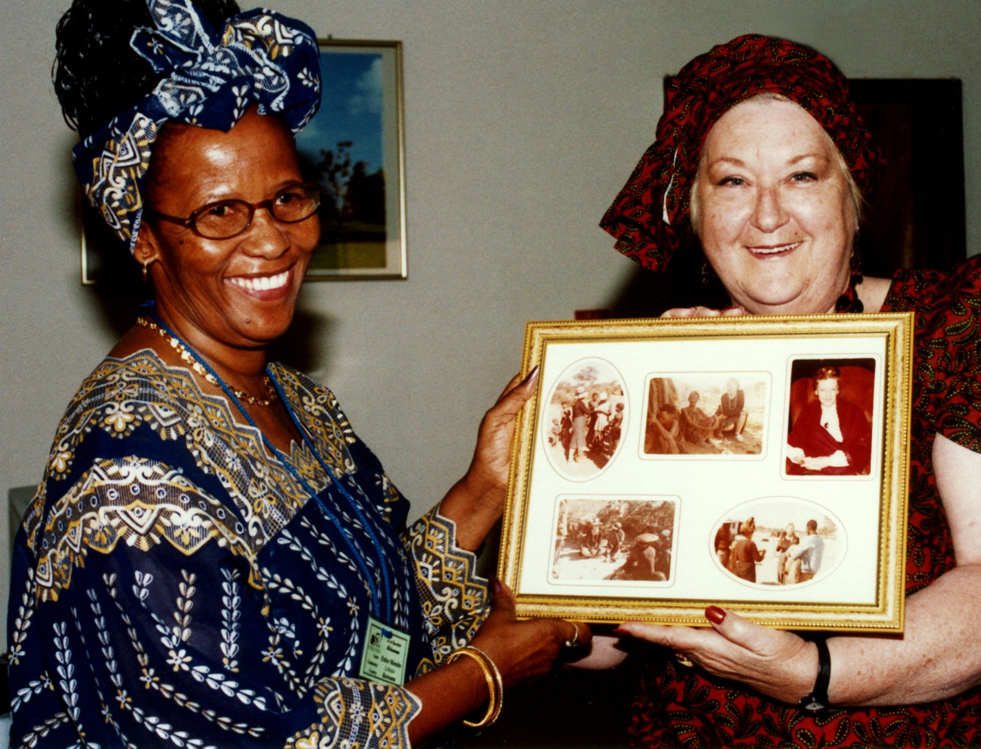 Maureen Page (right) presenting historic photographs to Esther Moncho at the Botswana Baha'i jubilee celebrations. Both women were members of the first National Spiritual Assembly of the Baha'is of Botswana.