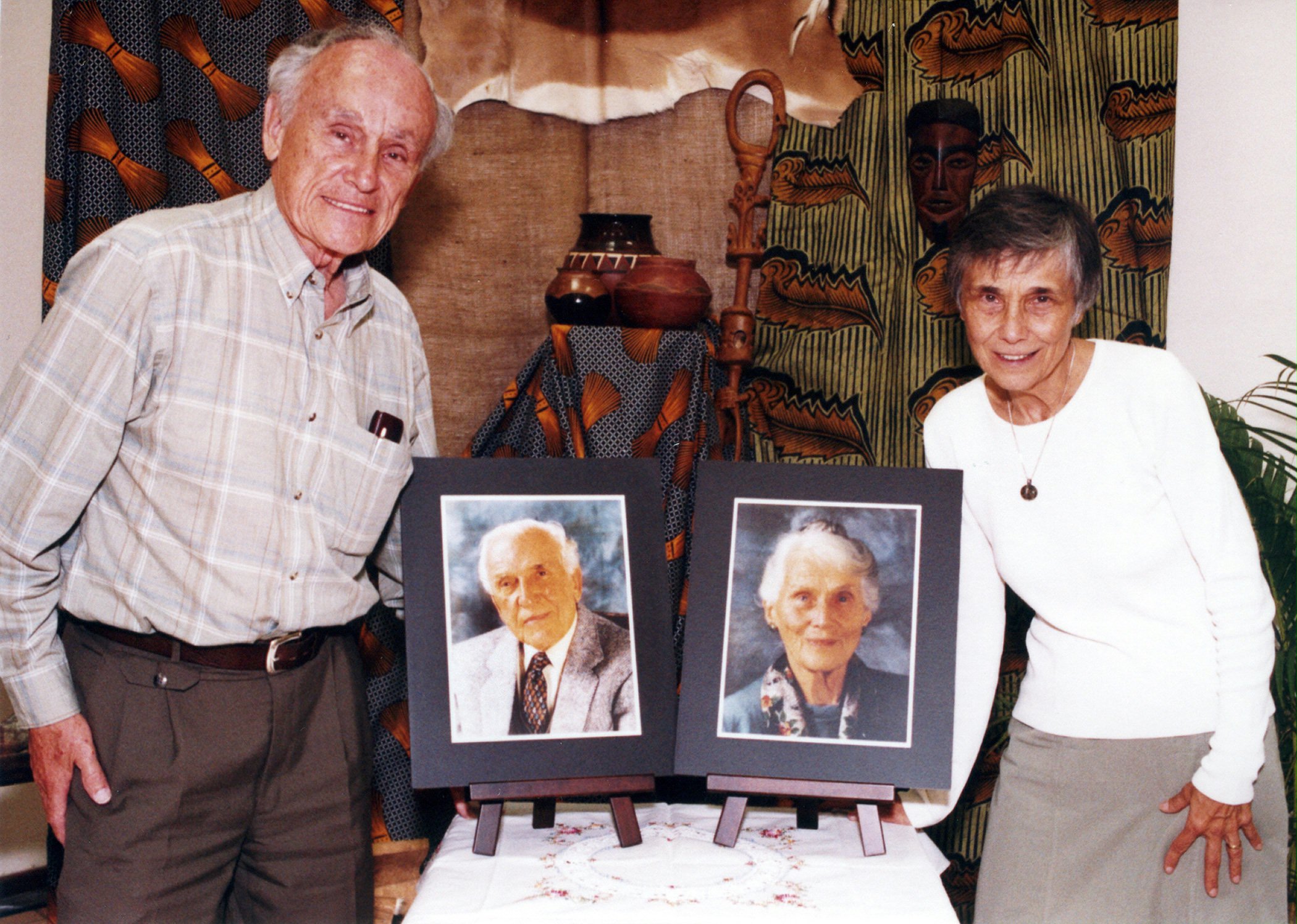 Gerald and Nina Robarts at the Botswana Baha'i jubilee celebrations with photographs of their parents, Hand of the Cause of God John Robarts and Audrey Robarts.
