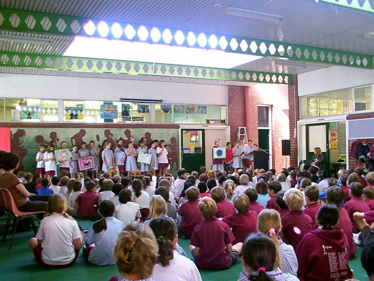 Members of a Baha'i Education in State Schools (BESS) class in Perth, Western Australia displaying their work at a school assembly.