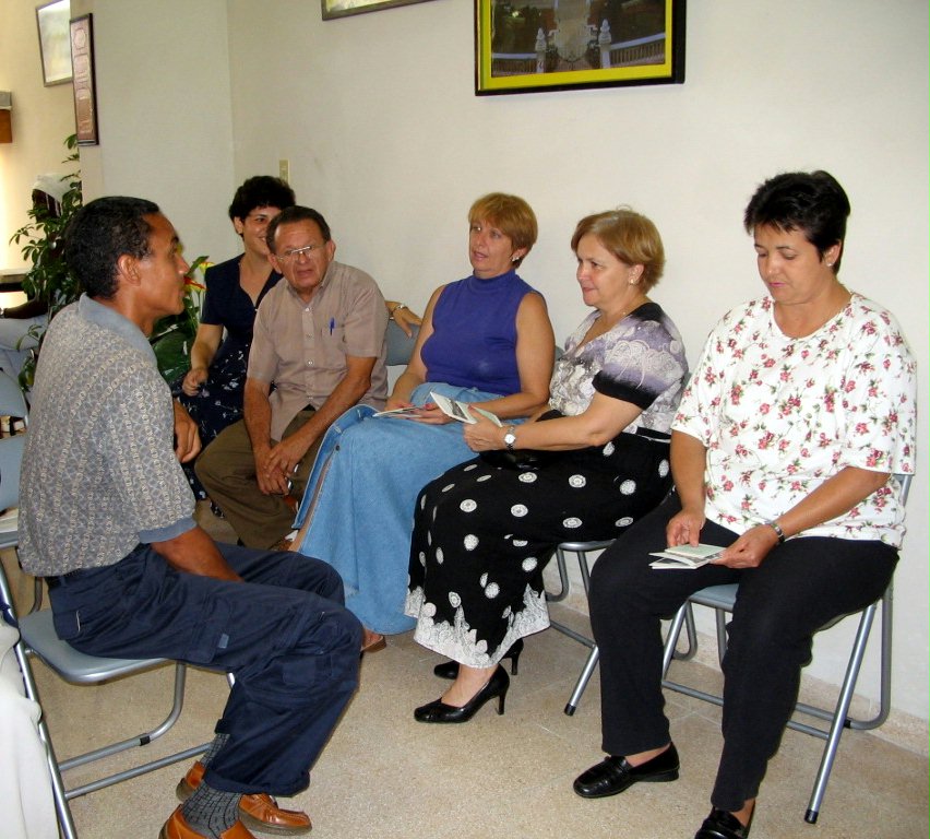 The chief of religious affairs in the Cuban government, Caridad Diego Bello (second from right), and her staff in discussion with some members of the National Spiritual Assembly of the Baha'is of Cuba at the national Baha'i center.