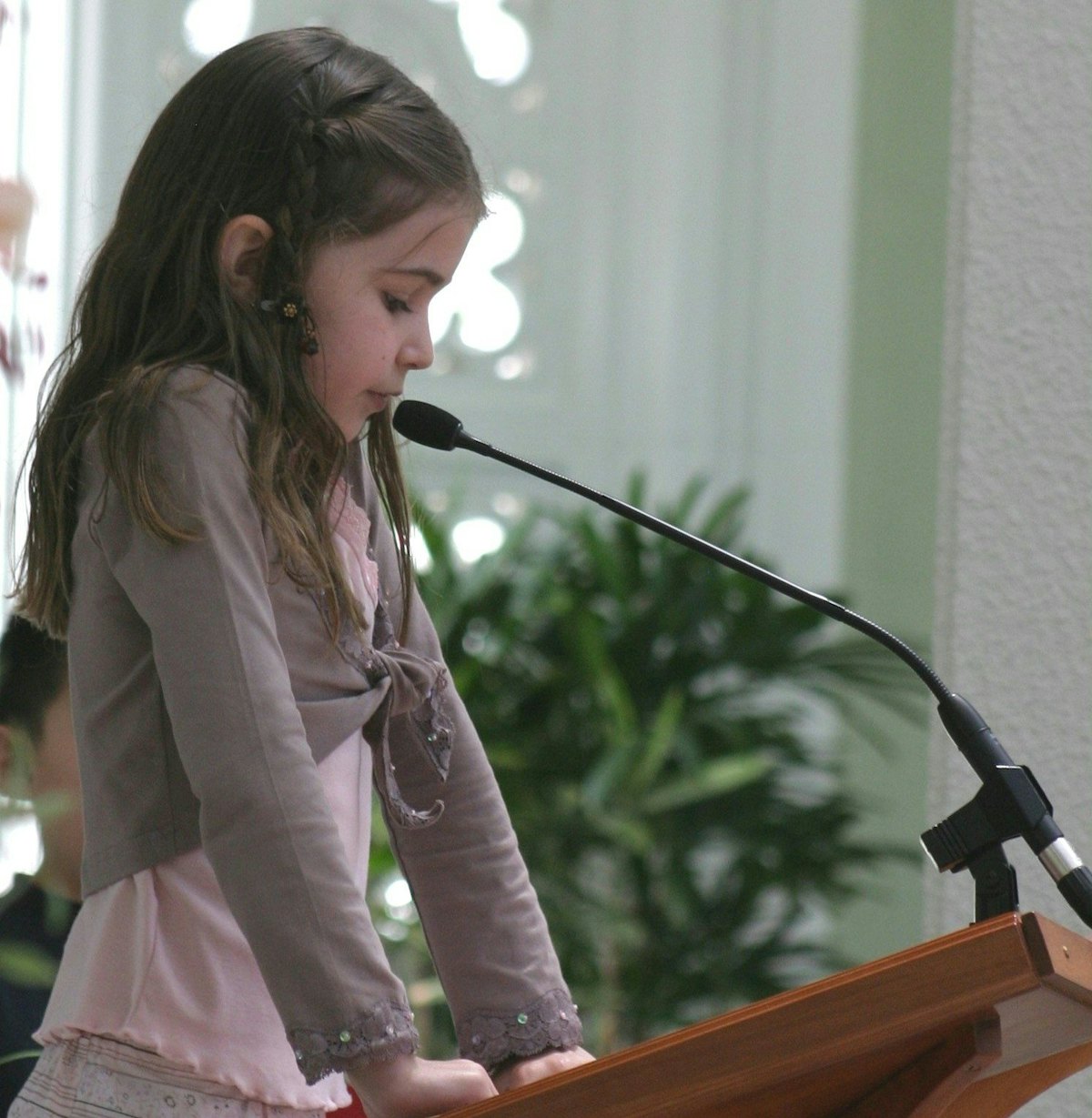 A pupil from a Sydney primary school, Chloe Maclean, reads a prayer at the service held in the House of Worship on Universal Children's Day. Photo by Saba Rouhani.