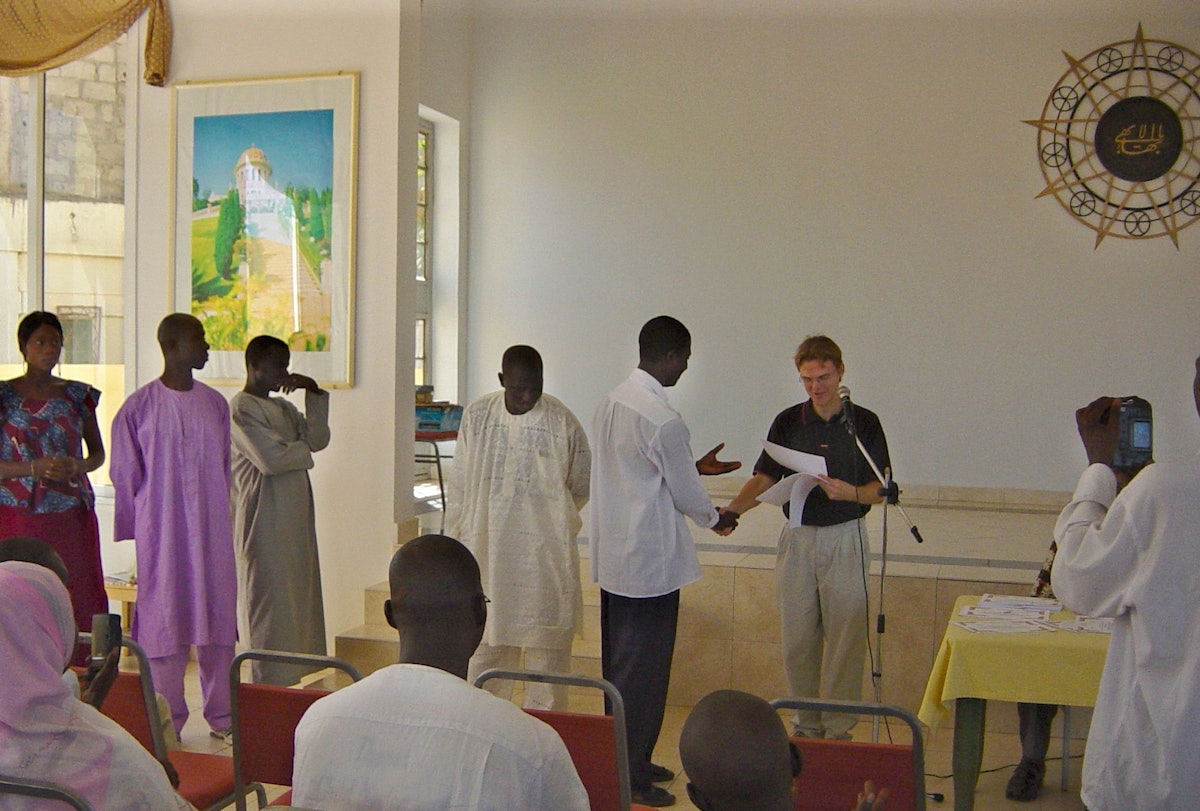 Graduates of the advanced computer course offered by the Baha'i commmunity of The Gambia receiving their certificates from the teacher, Eric Michell, at a ceremony in the Baha'i center.