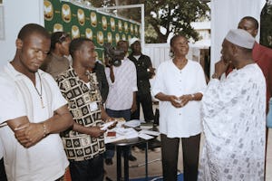 In Dakar, Senegal, Mr. Mame Birame Diouf, minister of Culture and Historical Heritage, at right with hat, visits the Baha'i display at an international book fair in December. Others, from left, all Baha'is, are Steve Pathe, Sandrine Toukam, Tchassanty Ouro-Gbeleou, and Jeanne Toukam.