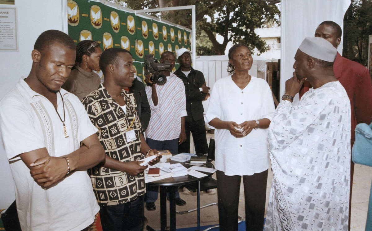 In Dakar, Senegal, Mr. Mame Birame Diouf, minister of Culture and Historical Heritage, at right with hat, visits the Baha'i display at an international book fair in December. Others, from left, all Baha'is, are Steve Pathe, Sandrine Toukam, Tchassanty Ouro-Gbeleou, and Jeanne Toukam.