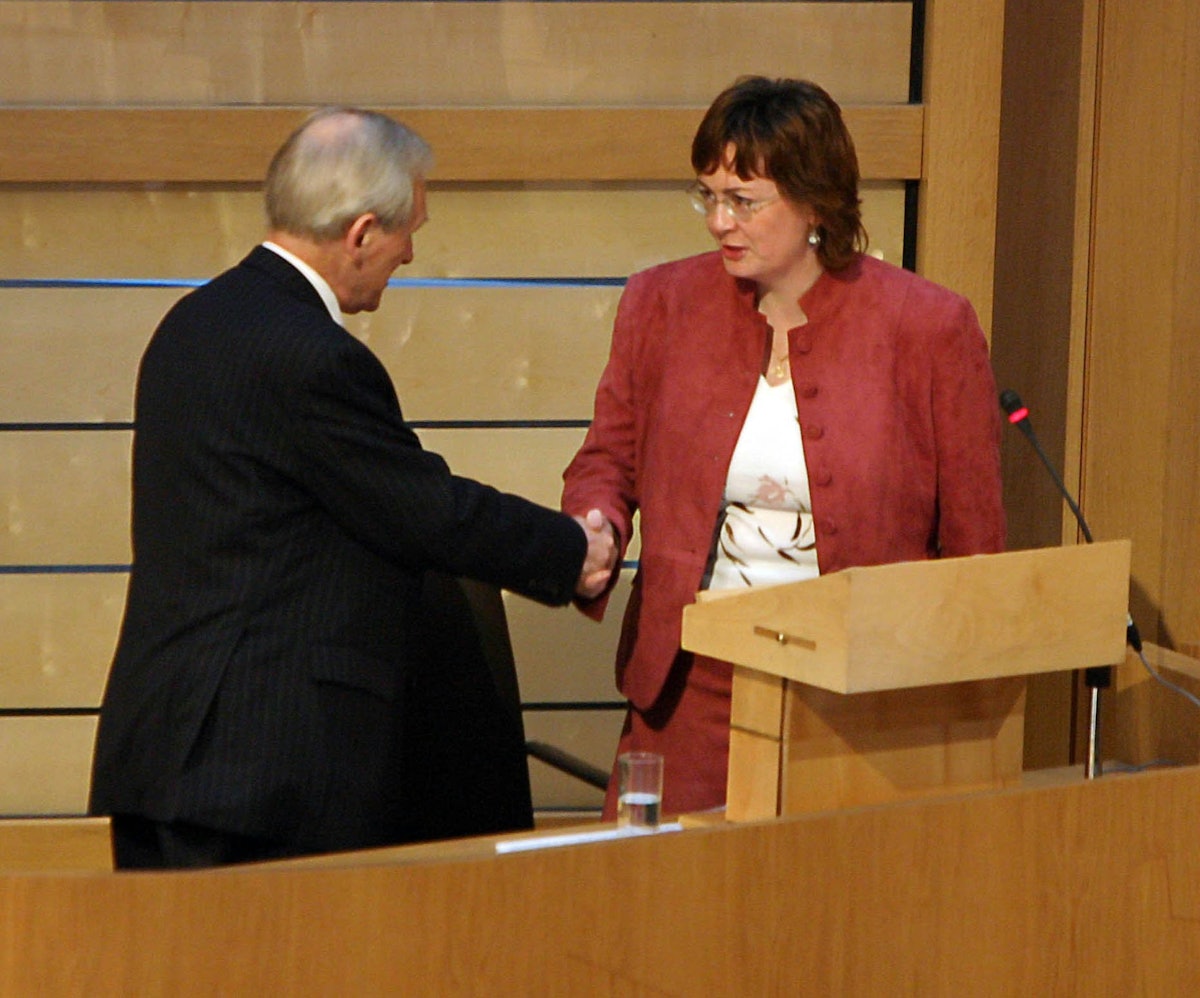 The Presiding Officer of the Scottish Parliament, the Right Honorable George Reid MSP, left, congratulates Ms. Carrie Varjavandi of the Scottish Baha'i Community after she gave her "Time for Reflection" address on 18 January 2006. (Photograph courtesy of and copyright by the Scottish Parliamentary Corporate Body 2005.)