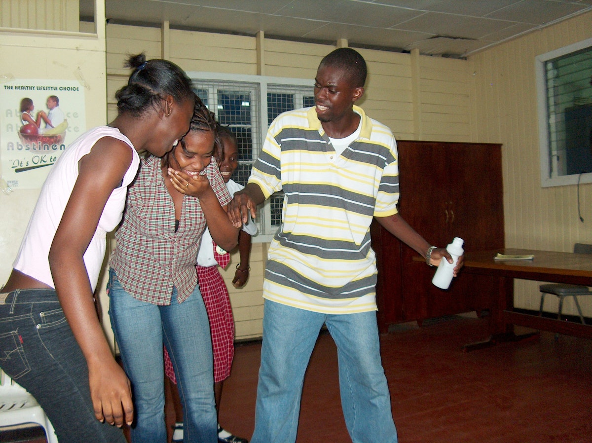 At the Future Club, Youth Can Move the World facilitators lead two dozen participants through a discussion on suicide prevention, which ended with the performance of various skits to illustrate what had been learned. At center is Rayana Jaundoo, pretending to drink Paraquat herbicide only to have her friends snatch the bottle away.