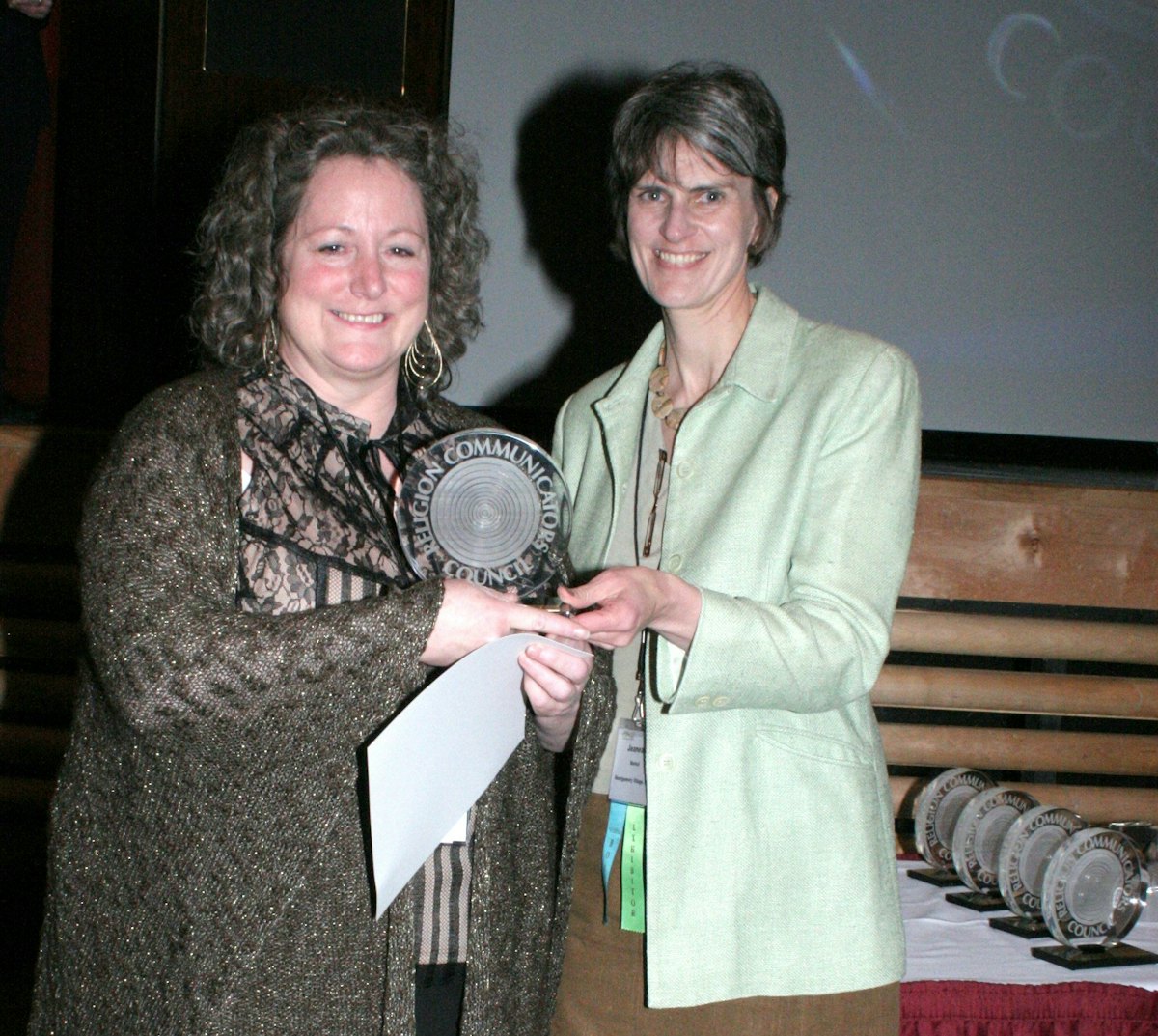Patricia Tomarelli, shown at left, receiving a "Best of Class" DeRose-Hinkhouse Award for "Sarah Farmer's Dream of Peace" in the "public relations materials" category, for special issue publications. Presenting the award, at right, is Jeanean Merkel, President of the Religion Communicators Council (RCC).