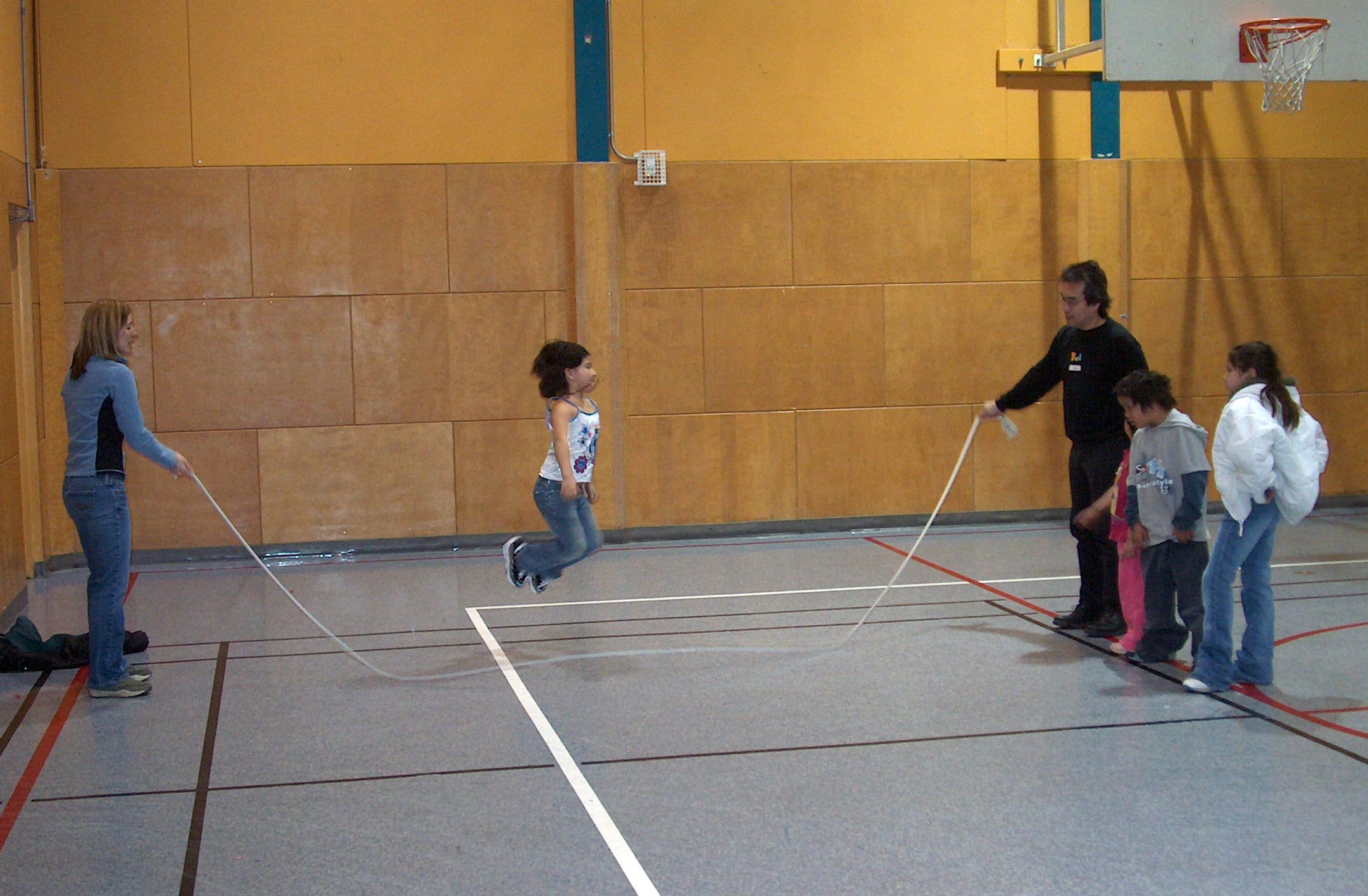 Rod Sasaki, far right, one of the Baha'i volunteers, helps out with skipping rope, one of several popular activities at the Sunday Family Virtues Breakfast at the Turtle Island Neighborhood Center in Winnipeg's Lord Selkirk Park.
