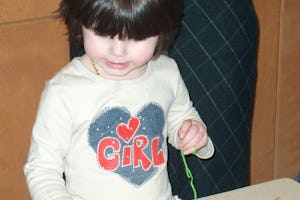 Jordan weaves a "God's eye" at the crafts table during the Family Virtues Breakfast in Winnipeg.