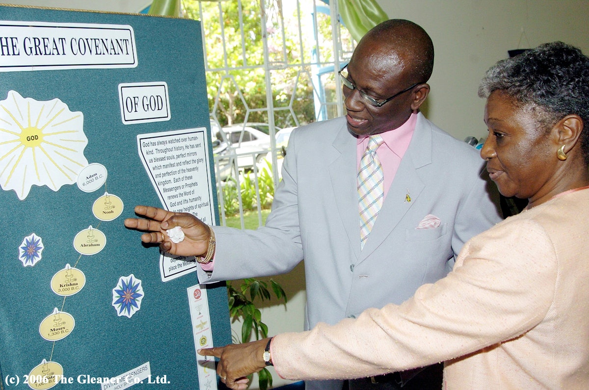Mayor Desmond McKenzie views a presentation at the Baha'i Day Breakfast with Dorothy Whyte, the chairperson of the National Spiritual Assembly of Jamaica.