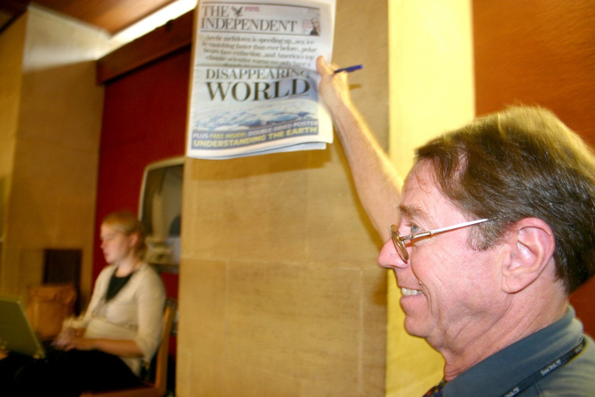 Arthur Dahl, president of the International Environment Forum, displays the front page of The Independent, published on 16 September 2006, with a major story about climate change. (Photograph by Gemma Parsons)