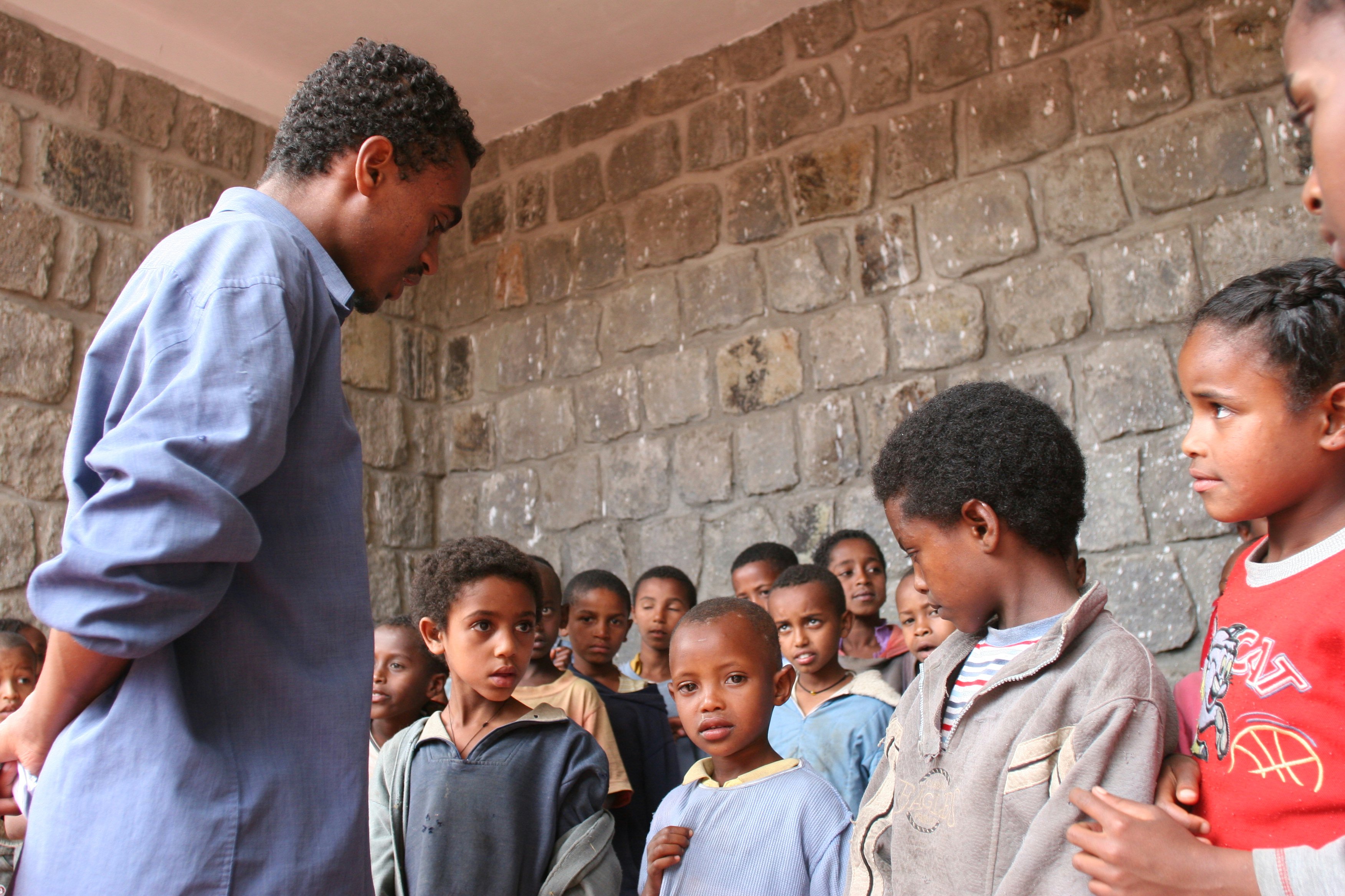 The teacher talks to the children as they prepare a concert for their parents. (Photograph by Ryan Lash)