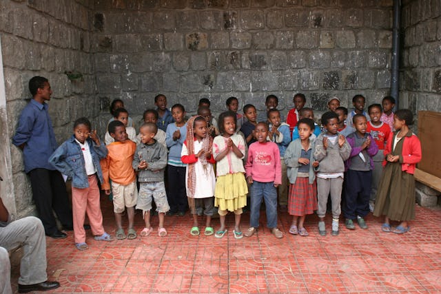 The children practice a song they plan to perform for their parents.