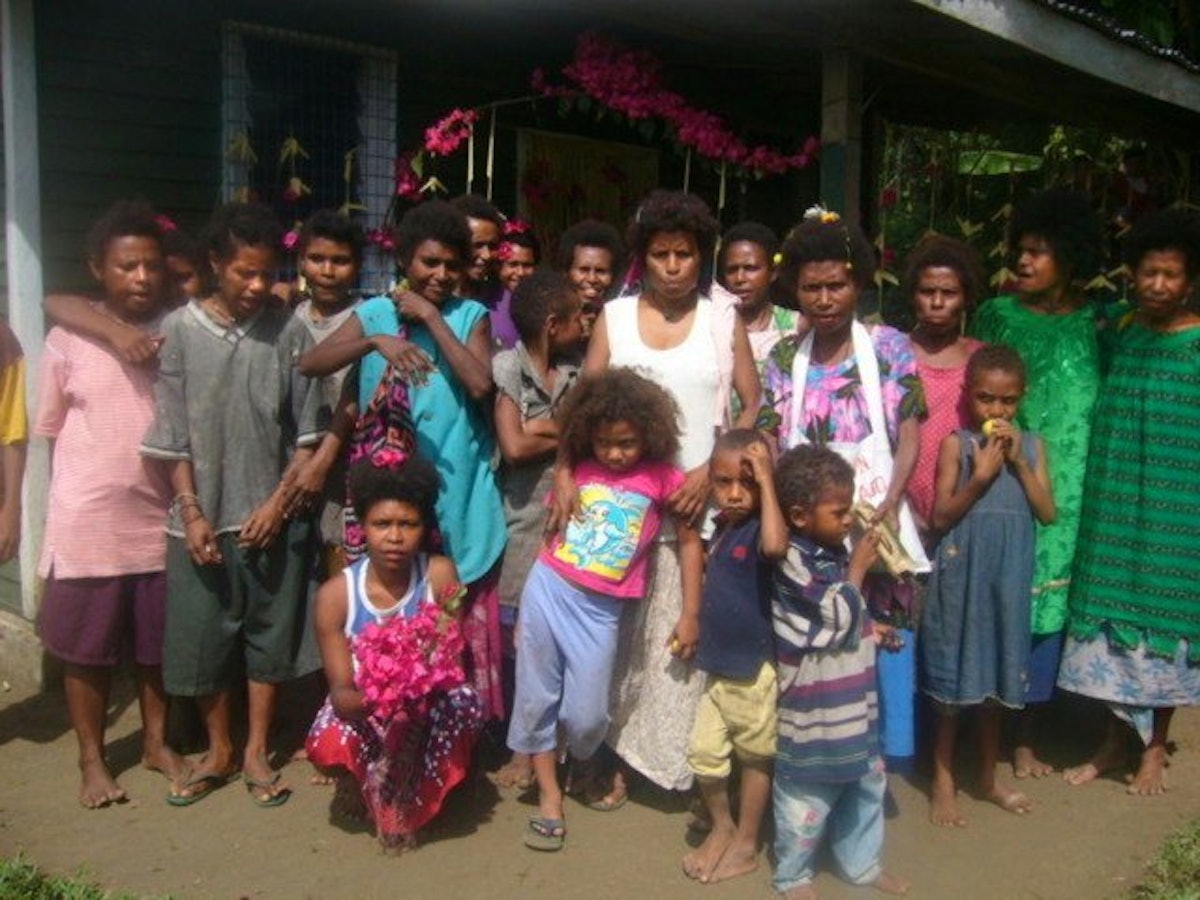 The Baha'i mothers of Mom village Papua New Guinea, proudly standing in front of their newly built medical aid post.