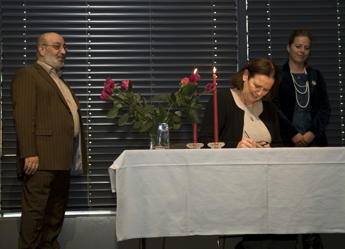Bridget McEvoy signing the "Forum for Interfaith Dialogue Policy Statement" on behalf of the Iceland Baha'i community.