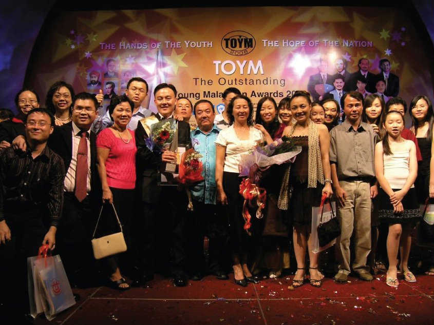 Mr. Lim (holding award) stands with a group of supporters from Jenjarom who went to Kuala Lumpur to celebrate his receiving the Young Outstanding Malaysian Award for his work with youth.