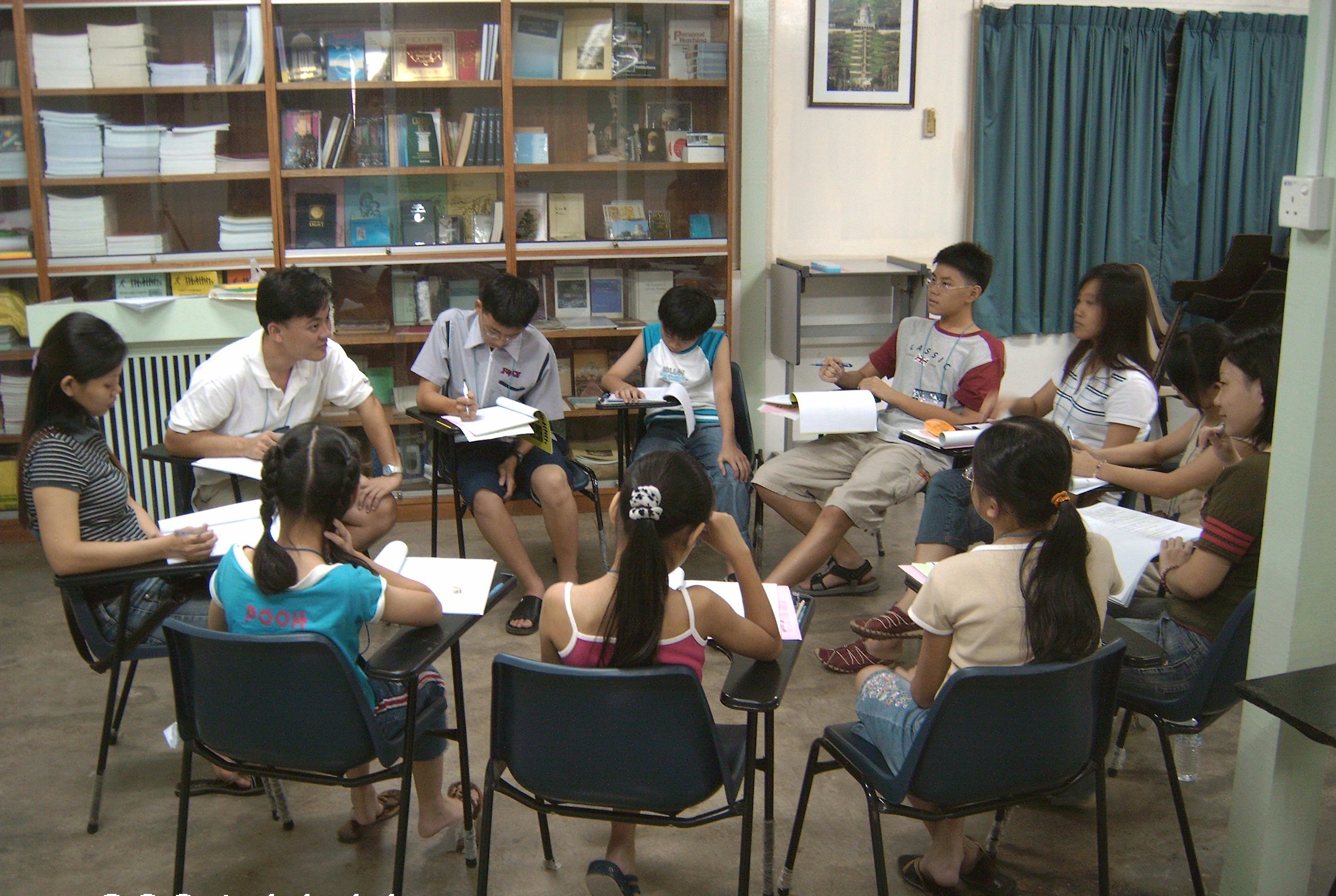 Mr. Lim (back left) facilitates a class for young teens in Jenjarom.
