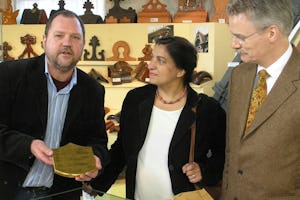 Huub Mombers, left, receives a gilded tile from the Shrine of the Bab for his museum in Alem, in Holland. Offering the tile on permanent loan, on behalf of the Baha'is of the Netherlands, are Elaheh Verhey-Shahgholi, center, and Jelle de Vries. The ceremony was on 3 February 2007.