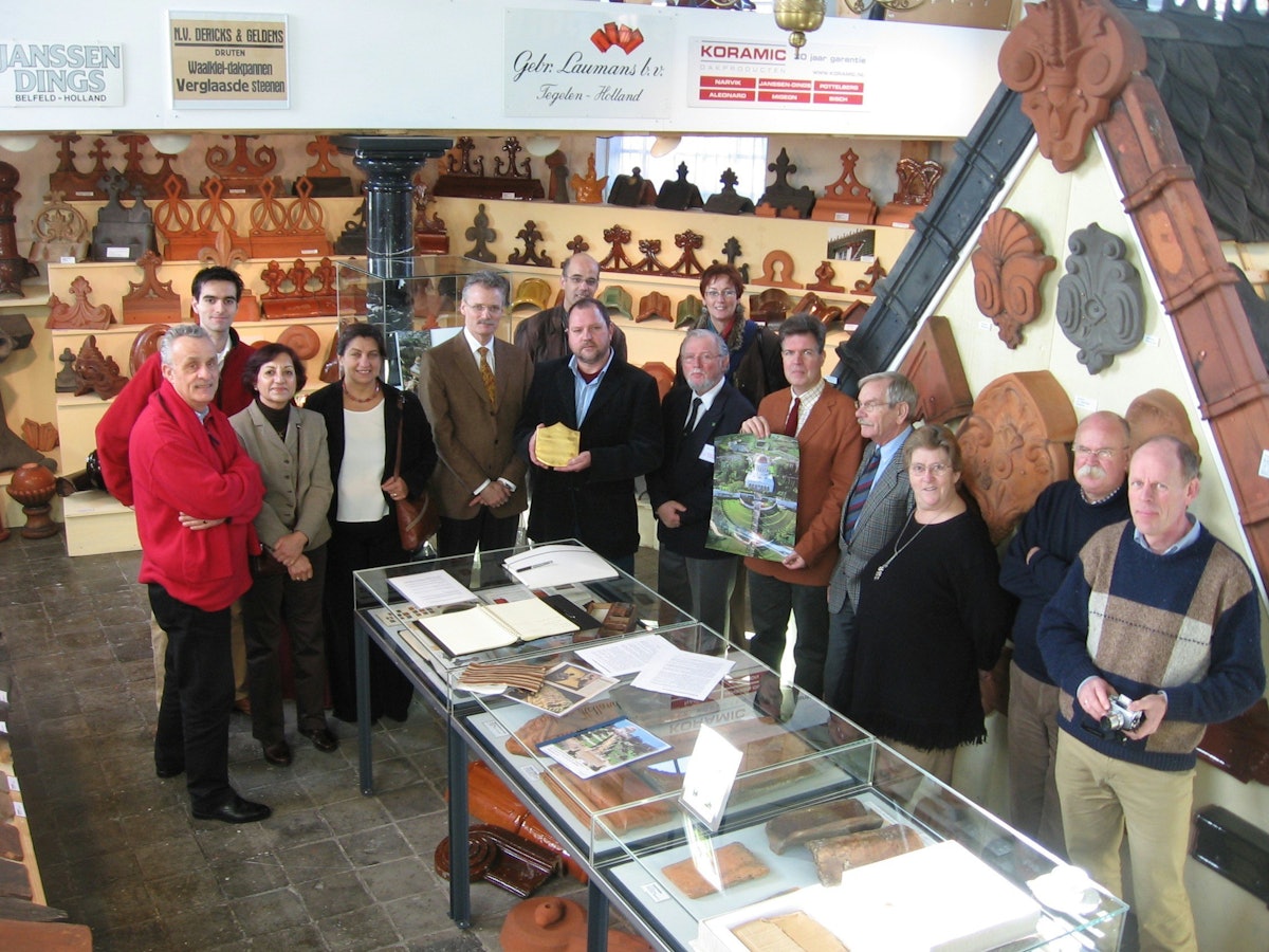 The Dutch Roof Tile Museum is located in an old church and contains several thousand roof tiles. Shown here are owner Huub Mombers, in center holding the gilded tile, and others present for the ceremony last month.