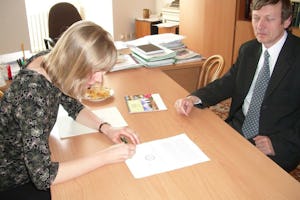 Baha'i representative Jitka Spillerova signs documents for the Baha'i application for state recognition. At right is Jan Juran of the Ministry of Culture. The signing took place on 19 April 2007.