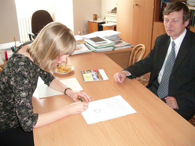 Baha'i representative Jitka Spillerova signs documents for the Baha'i application for state recognition. At right is Jan Juran of the Ministry of Culture. The signing took place on 19 April 2007.