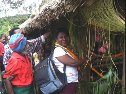 Kessia Ruh, a Baha'i counselor invited as a special guest to the inauguration of new classrooms at Bunisi Elementary School in Papua New Guinea, cuts the ribbon at one of the new buildings.