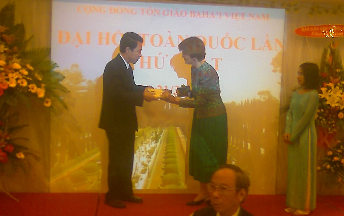 Mrs. Joan Lincoln, an emissary from the Universal House of Justice, presents a gift to the government of Vietnam, represented by Nguyen Thanh Xuan of the Government Committee for Religion, during the Baha'i convention.