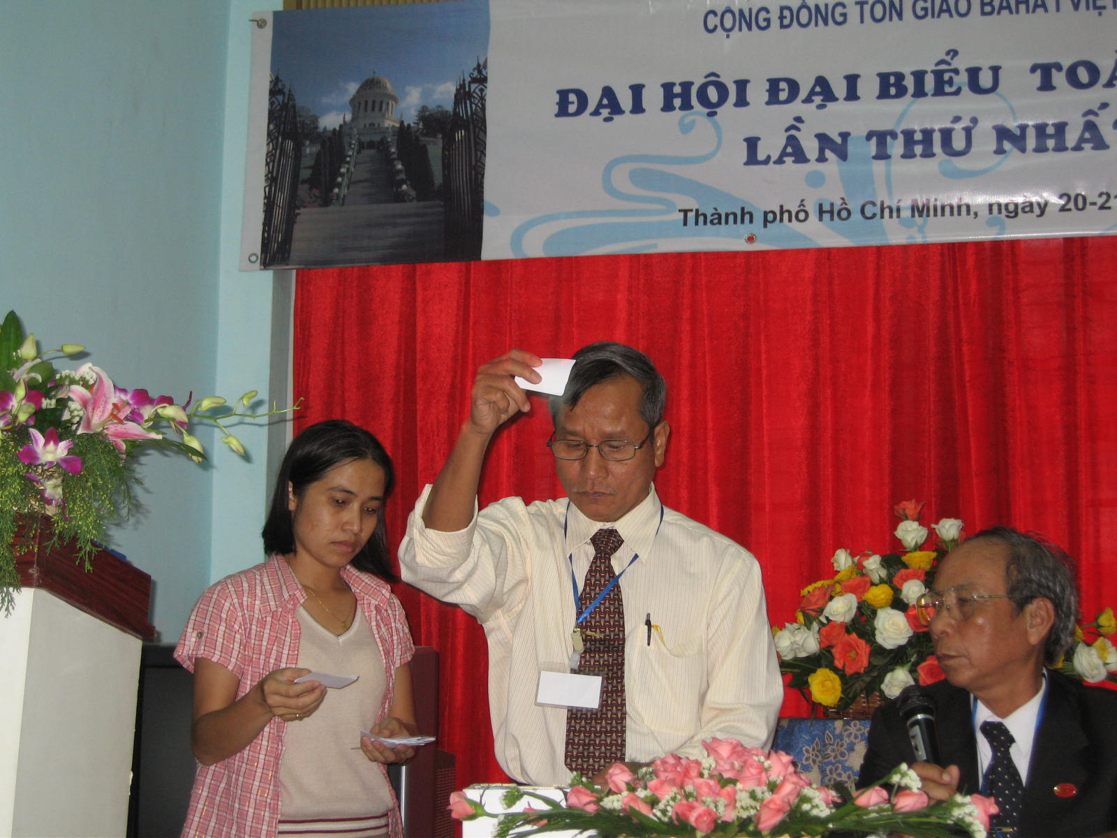 Tellers count the votes during the election of the National Spiritual Assembly. Three government representatives were seated in the audience to observe the election process.