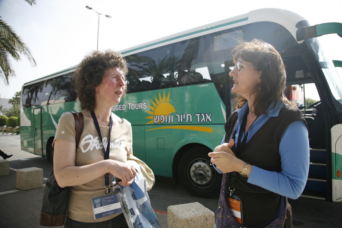 A delegate from the nation of Georgia on the eastern end of the Black Sea talks with a staff member of the Baha'i World Centre before boarding a bus at the convention center.