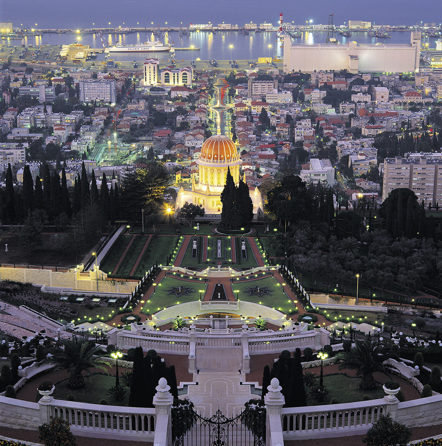 The terraces and gardens at the Shrine of the Bab stretch for a kilometer up the side of Mount Carmel in Haifa. The property overlooks the lower part of the city and Haifa Bay, with the Mediterranean Sea in the distance.