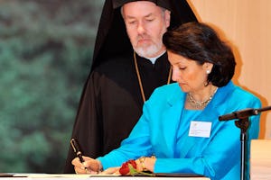 نمایندۀ جامعۀ بین المللی بهائی، خانم بانی دوگال، روز دهم دسامبر در لاهه بیانیۀ سال ۲۰۰۸ «ایمان و دین در حقوق بشر» را امضا میکند. شخص ناظر بر این امر عالیجناب آتناگوراس (پکستات) اسقف امور حقوق بشر است از سینوپه در بلژیک.