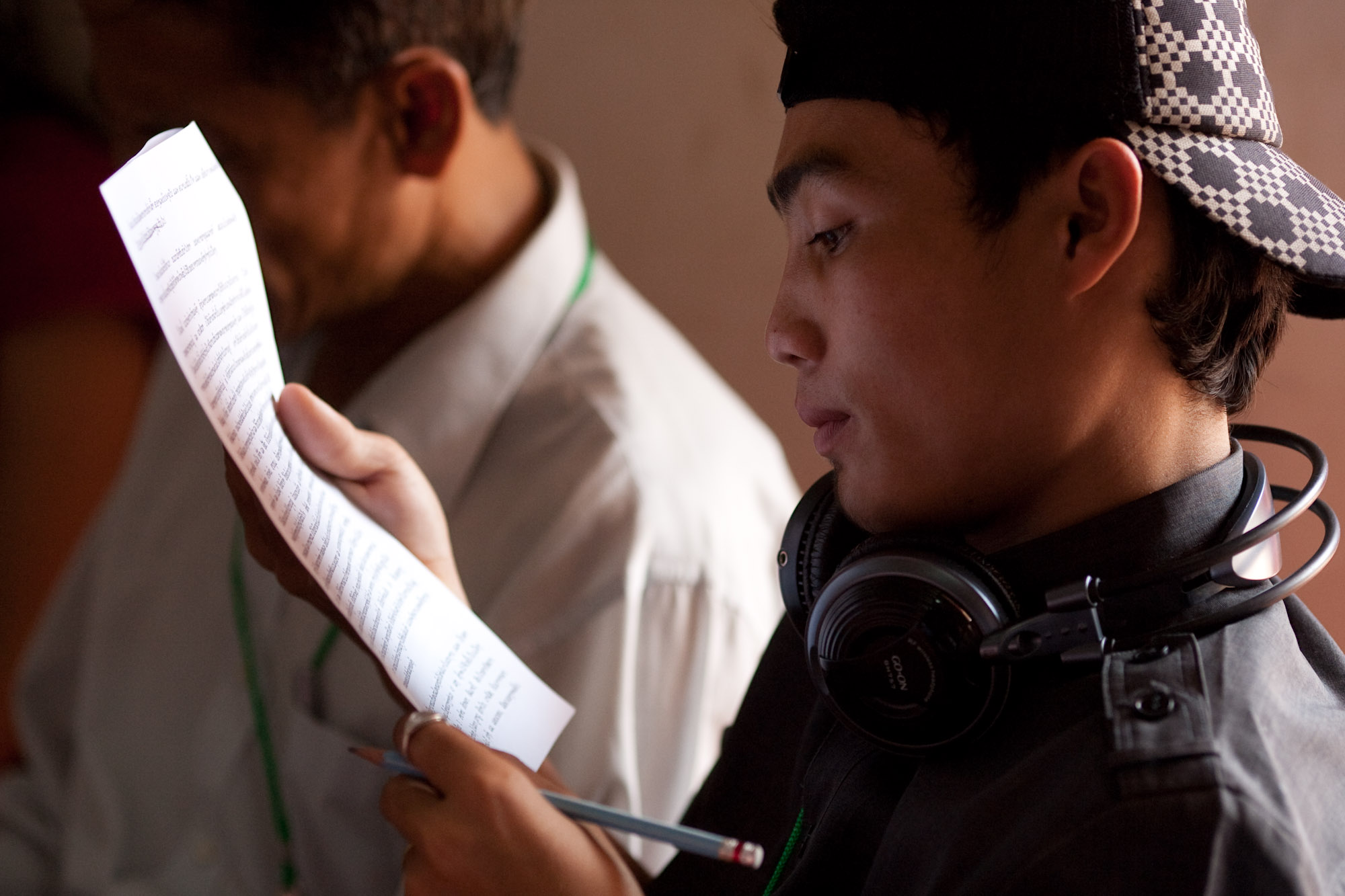 A young man from Laos who traveled to Cambodia for the conference studies a message to the gathering from the Universal House of Justice.