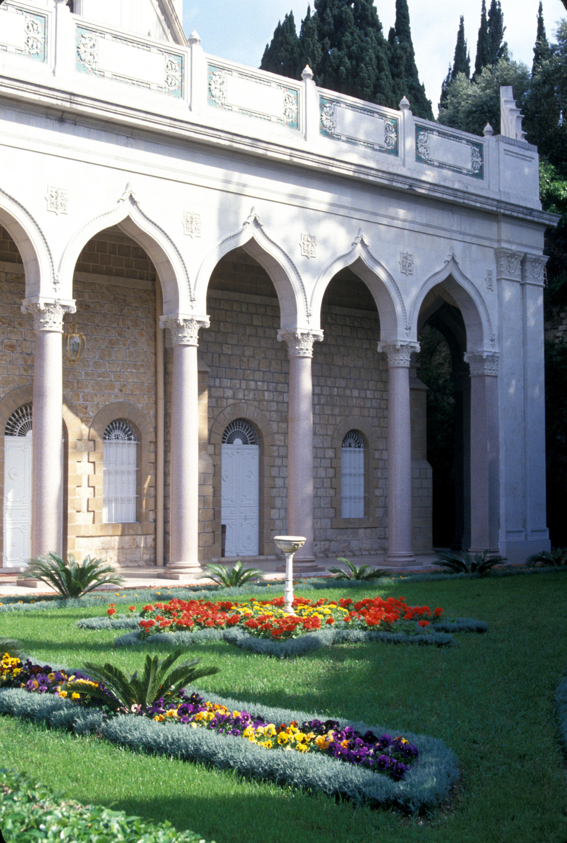 A formal colonnade, shown here, now surrounds the original building of the Shrine of the Bab. The golden dome rises above. (Photo copyright Baha'i World Centre)