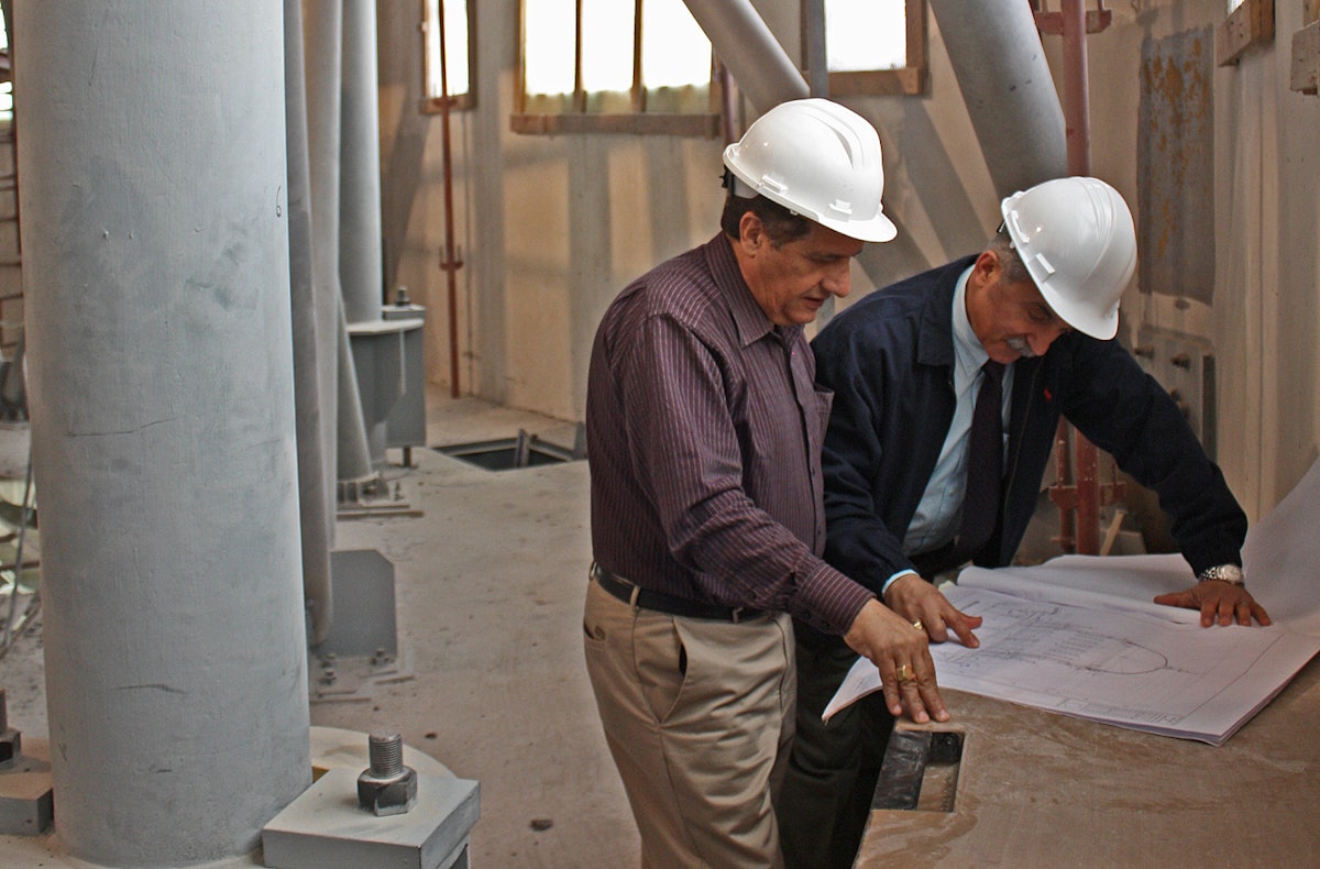 Saeid Samadi, right, architect and project manager for the shrine restoration project, and Enayat Rohani, engineer and site supervisor, confer as the work at the shrine progresses. (Baha’i World Centre photo. All rights reserved.)