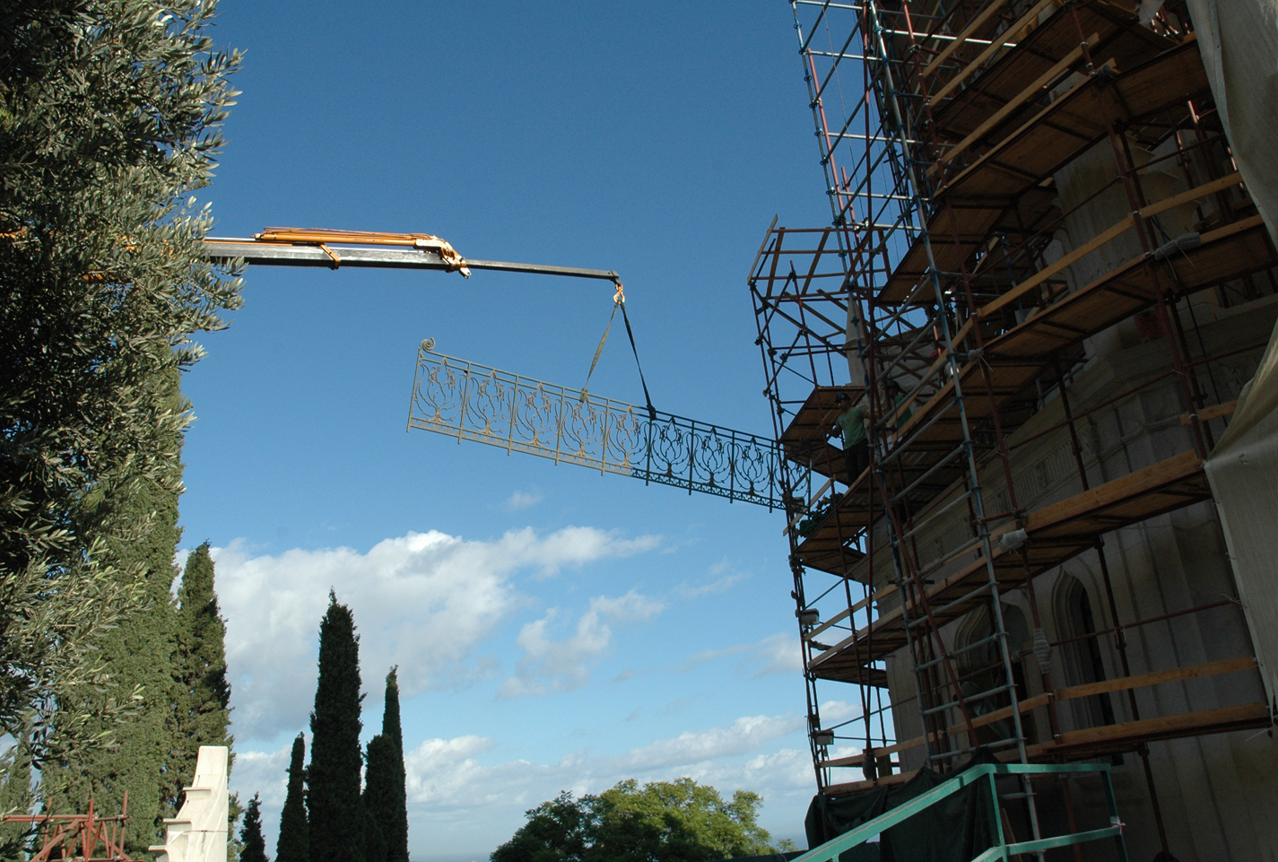 Refurbishing the ornamental metal balustrades required lowering them by crane and transporting them to a workshop. Staff members have devoted 2,000 to 3,000 hours to restoration of the original pieces. (Baha’i World Centre photo. All rights reserved.)