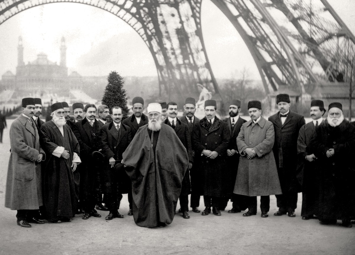 'Abdu'l-Baha and His entourage beneath the Eiffel Tower in Paris, in 1912. "I in the East, and you in the West, let us try with heart and soul that unity may dwell in the world," He told His French audience, "that all the people may become one people, and that the whole surface of the earth may be like one country."