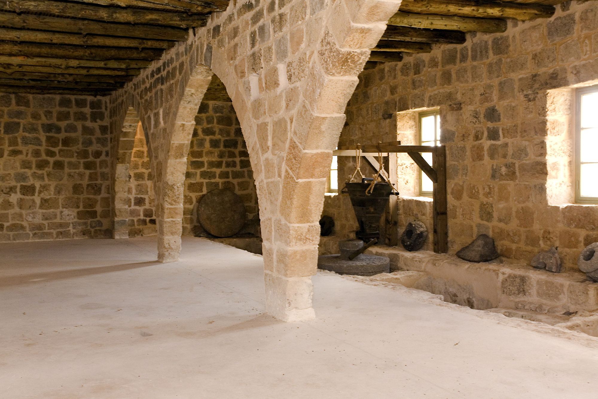 An interior view of the fully-restored mill building with its working mill on the right. The mill complex with its canals, arches and buildings, is unique of its kind and size - and condition of conservation - in Israel.