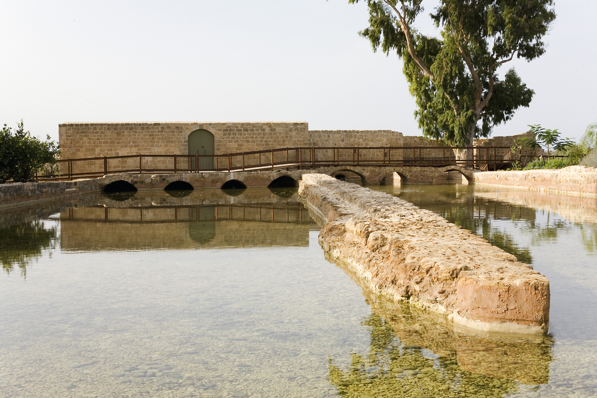 A view of the entrance to the fully-restored flour mill building close to the Ridvan Garden, showing a part of the water channels which once powered 15 mills in parallel. The building was chosen for full restoration because its structure was largely intact and only needed a new roof. Accessibility to the mills is provided by an extensive wooden boardwalk that encircles the restored structures.