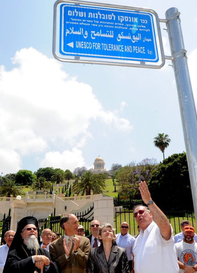 A road sign, in Arabic, English and Hebrew, for the UNESCO for Tolerance and Peace Square is unveiled in Haifa, Israel, 29 May 2011, in the presence of: (front row, from left to right) the Most Reverend Dr. Elias Chacour – Archbishop Metropolitan of the Melkite Greek Catholic Church for Acre, Haifa, Nazareth and All Galilee; Dr. Albert Lincoln – Secretary General of the Baha'i International Community; Ms. Irina Bokova – Director General of UNESCO; and Advocate Yona Yahav, Mayor of Haifa.