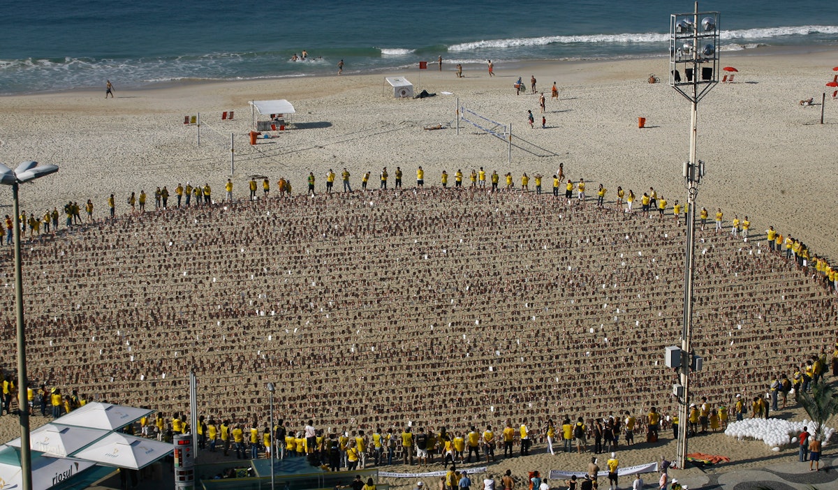 In Brazil, human rights campaigners circle around almost 8,000 images depicting the faces of Iran's seven imprisoned Baha'i leaders, on Rio's Copacabana Beach. The photographs were arranged to represent the world, and the union of people of all races and nations.