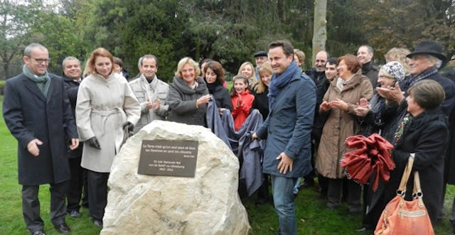 Luxembourg City's mayor Xavier Bettel – pictured right of the stone – unveiled a monument on 30 October 2012, marking the 50th anniversary of the first election of the National Spiritual Assembly of the Baha'is of Luxembourg.