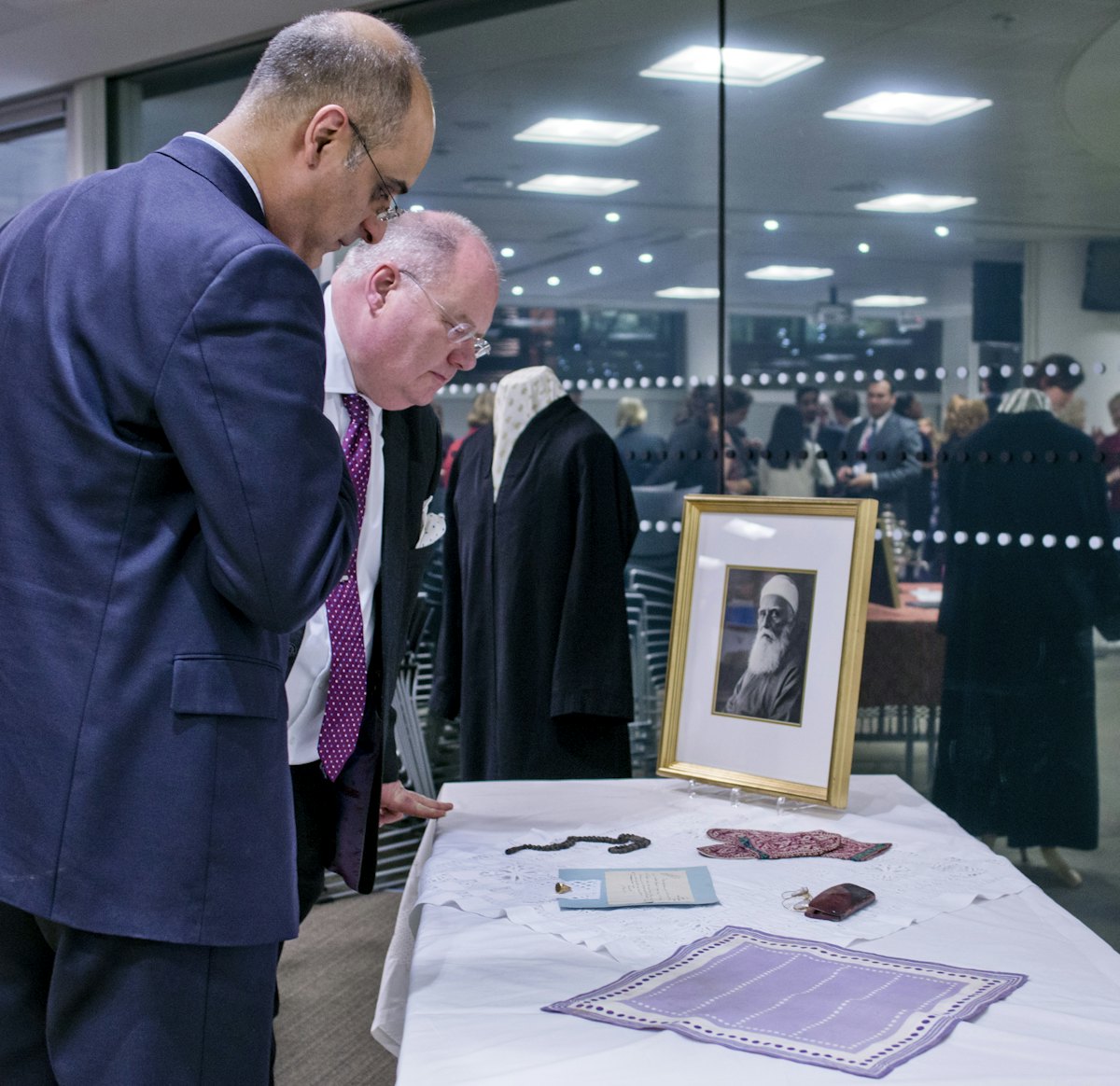Eric Pickles MP, Secretary of State for Communities and Local Government– pictured right – examines personal and historical items associated with ‘Abdu’l-Baha at a reception hosted by the British government for the Baha’i community, 28 November 2012.