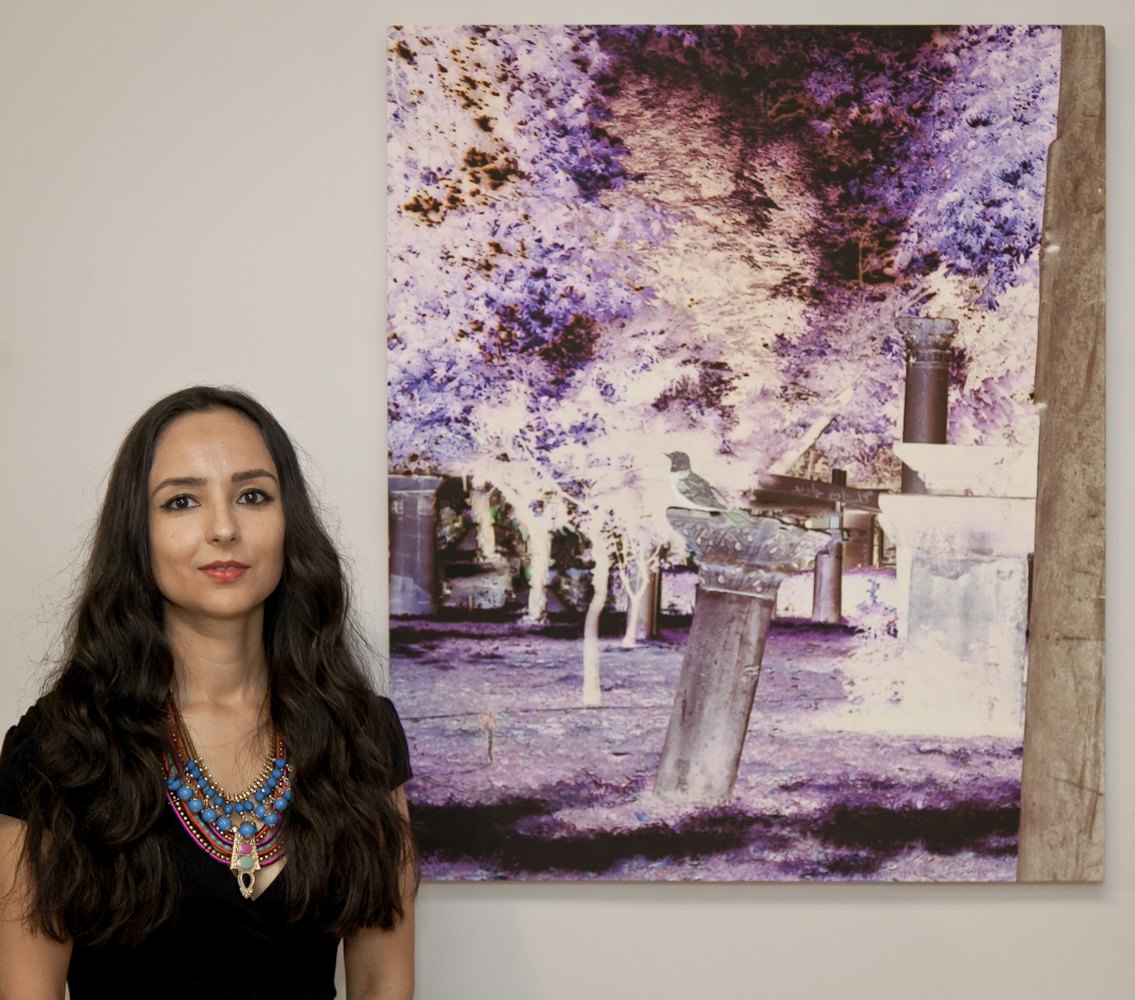 Shadi Eshragi, pictured with one of her artworks titled "Eternal Garden." The piece was inspired by a telephone call she received, telling her that the Baha'i cemetery in Shiraz where her grandmother is buried had been desecrated. The work, said Ms. Eshragi, "essentially asks the question, 'What peace is left for the living when their dead cannot rest in peace?'"